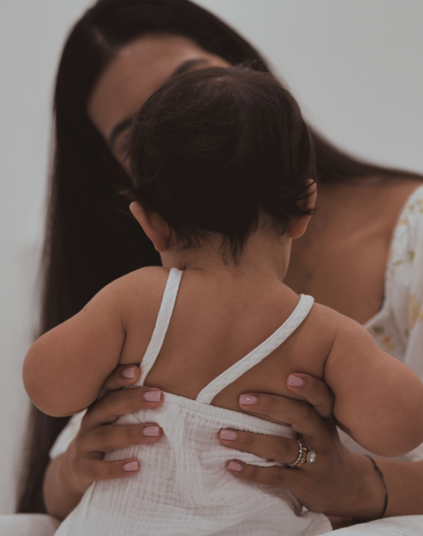 Chiropractor gently holding a baby during a family care session at Bump & Beyond Clinic in Wimbledon