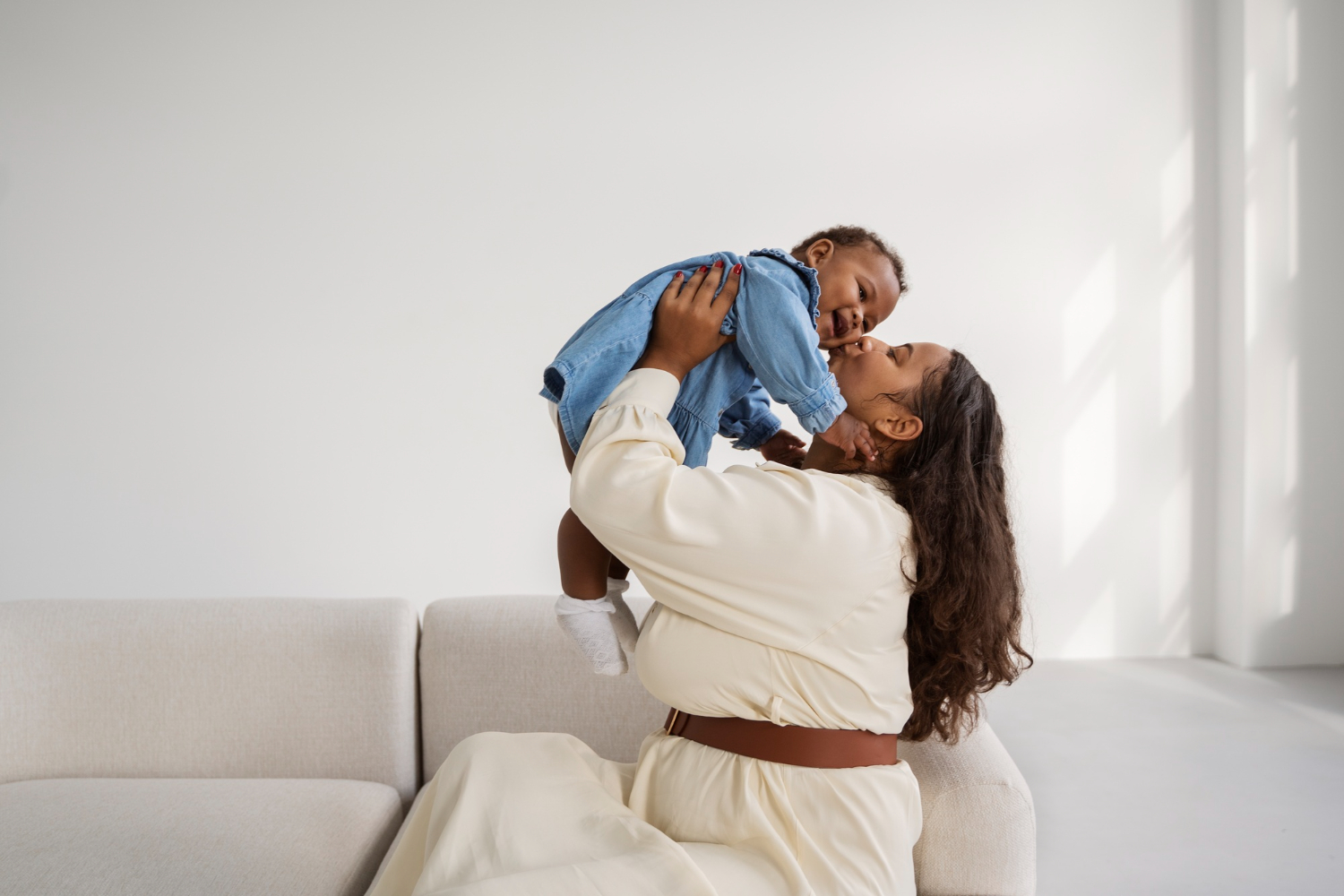 Smiling mother lifting her baby, sharing a positive experience at Bump and Beyond