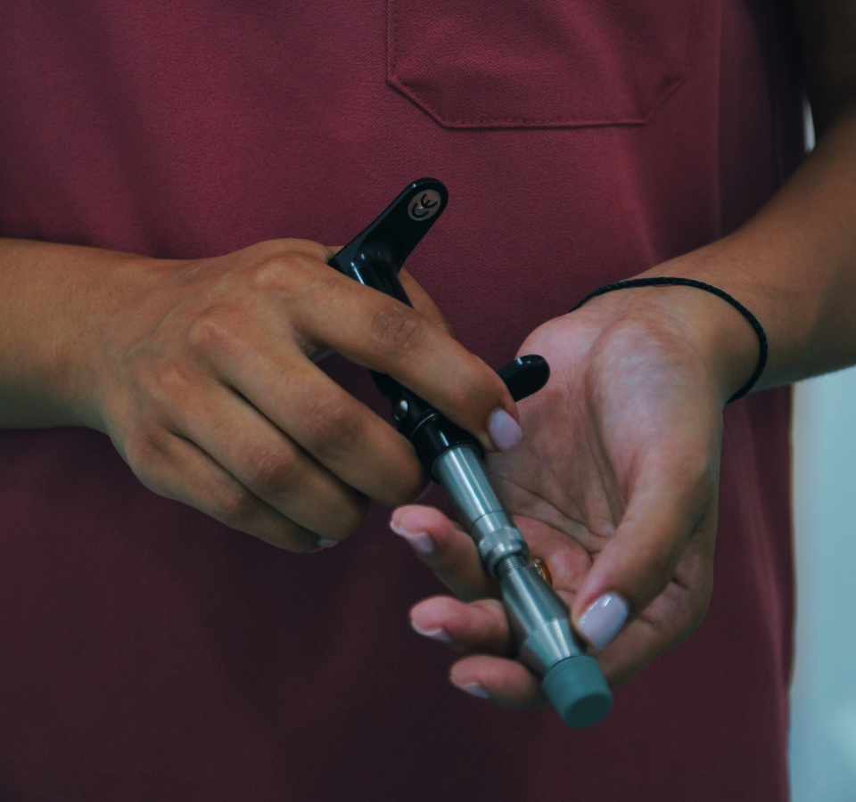 Bump and Beyond chiropractor holding an adjustment tool during treatment in Wimbledon clinic