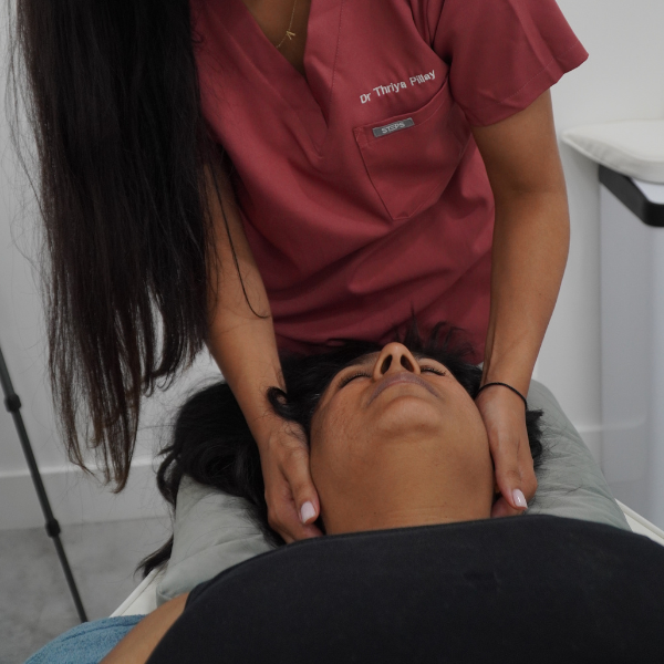 Dr Thriya providing gentle chiropractic adjustment for a mum in Wimbledon